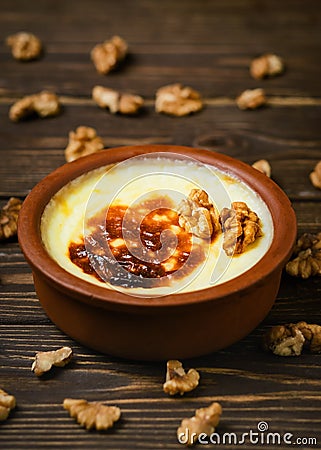 Baked rice pudding - turkish milk dessert sutlac in earthenware casserole with walnuts. Turkish Cuisine dessert varieties. Close Stock Photo
