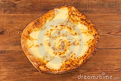 Baked round khachapuri on dish on rustic table, top view Stock Photo