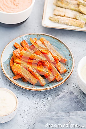 Baked season carrot sticks with sauce and hummus Stock Photo