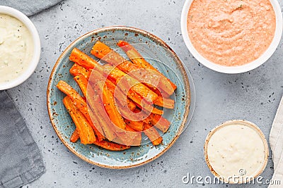 Baked season carrot sticks with sauce and hummus Stock Photo