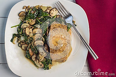 baked season salmon with a side of sauteed spinach and mushrooms Stock Photo