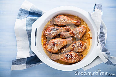 Baked spicy chicken legs with sesame on blue wooden background Stock Photo