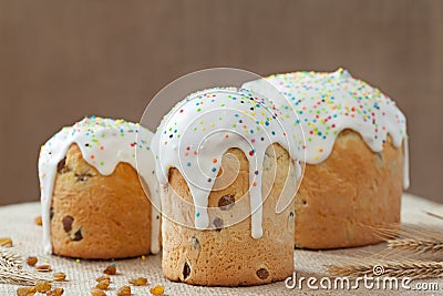 Baked sweet dessert traditional easter cake panettone also called kulich glazed with icing and raisins on vintage textile Stock Photo