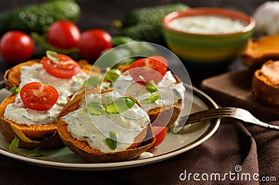 Baked sweet potatoes served with tzatziki dip. Stock Photo