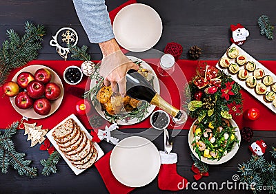 Baked turkey. Christmas dinner. The Christmas table is served with a turkey, decorated with bright tinsel and candles. Stock Photo