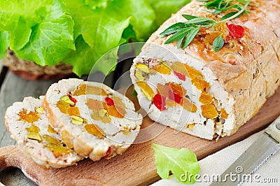 Baked turkey roll stuffed with dried apricots, cherries and pistachios Stock Photo