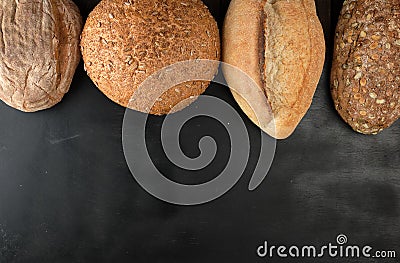 baked various loaves of bread on a black background Stock Photo