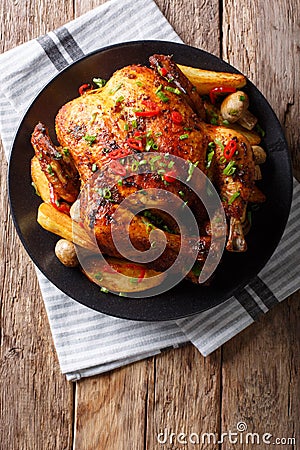 Baked whole chicken with mushrooms and potatoes close-up on a pl Stock Photo