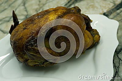 Baked whole chicken with mushrooms and potatoes close-up on a plate on a table. vertical top view from above . Stock Photo