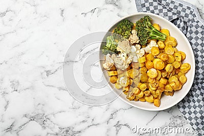 Baked yellow carrot with broccoli and cauliflowers on white marble table, top view. Space for text Stock Photo