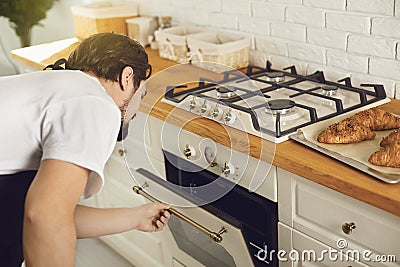 Baker chef checks the oven in the kitchen bakery. Stock Photo