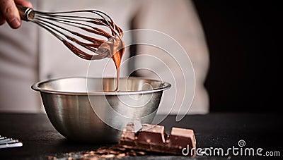 Baker or chef whisking melted chocolate in a bowl Stock Photo