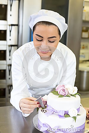 Baker decorates a cake with food dye Stock Photo