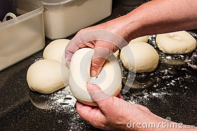 Baker forming bagels from dough Stock Photo