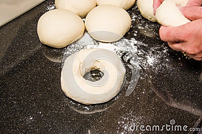 Baker forming bagels from dough Stock Photo