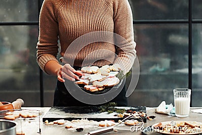 Baker holding dish with gingerbread cookies Stock Photo