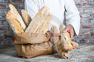 Baker holding traditional bread french baguettes Stock Photo