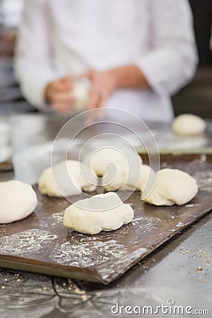 Baker kneading uncooked dough on worktop Stock Photo