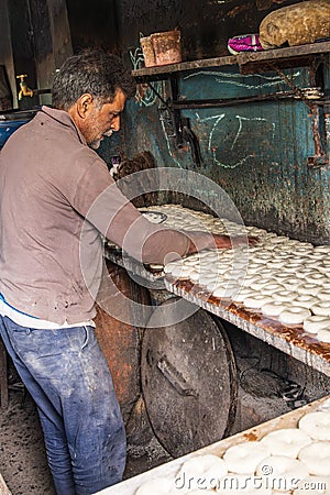 Baker making bagel shaped bread rolls Editorial Stock Photo