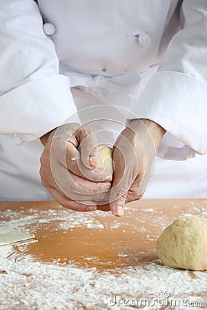 Baker making bread, kneading a dough Stock Photo