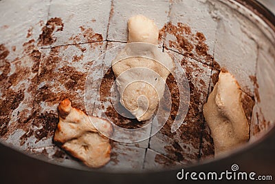 Baker making turkish pita bread in tandoor clay oven. Baking process. Stock Photo