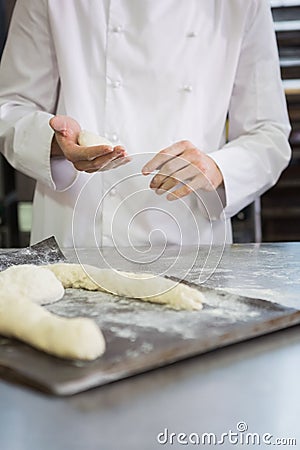 Baker making uncooked dough on tray Stock Photo