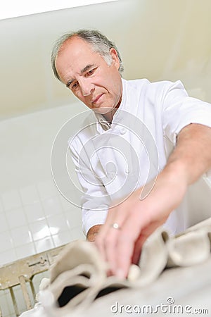 Baker prepring bread for oven Stock Photo