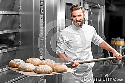 Baker taking out from the oven baked buckweat bread Stock Photo