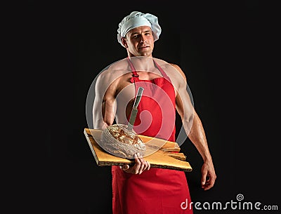 Bakery advertising. Cooking and baking. Chef baker man in apron. Sexy guy with bread and knife. Stock Photo