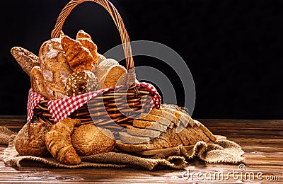 Bakery Assortment on wooden table on dark background. Still Life of variety of bread with natural morning light Stock Photo