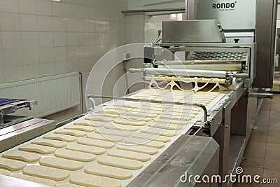 Forming dough on modern bakery equipment. Editorial Stock Photo