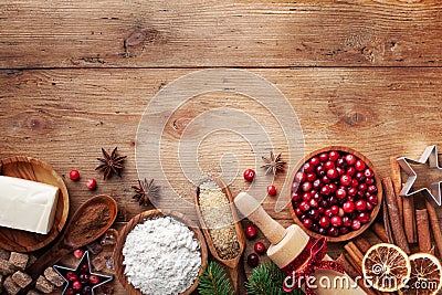 Bakery background with ingredients for cooking Christmas baking. Flour, brown sugar, butter, cranberry and spices on wooden table Stock Photo