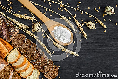 Bakery background top view. Crusty buns and loaves of bread on dark grey chalkboard background Stock Photo