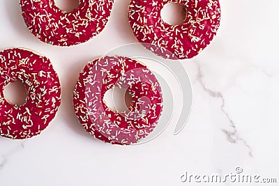 Frosted sprinkled donuts, sweet pastry dessert on marble table background, doughnuts as tasty snack, top view food brand flat lay Stock Photo