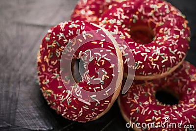 Frosted sprinkled donuts, sweet pastry dessert on rustic wooden background, doughnuts as tasty snack, top view food brand flat lay Stock Photo