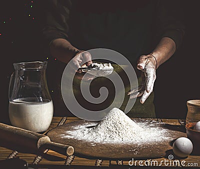 Bakery. Man preparing bread, Easter cake, Easter bread or cross-buns on wooden table in a bakery close up. Man preparing bread dou Stock Photo