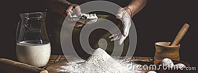 Bakery. Man preparing bread, Easter cake, Easter bread or cross-buns on wooden table in a bakery close up. Man preparing bread dou Stock Photo