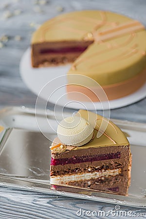 Bakery with piece of unusual yellow mousse cake with almond dacquoise, raspberry confit, crispy layer with caramelized Stock Photo