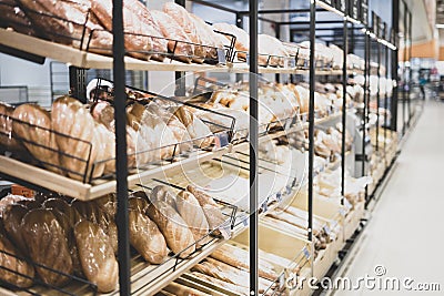 Bakery showcase. Freshly baked bread. Presentation of bread in a shop window of a hypermarket. Stock Photo