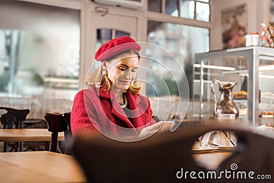 Mature appealing stylish woman feeling relaxed sitting in bakery on weekend Stock Photo