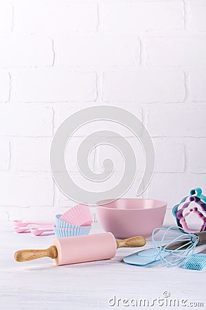 Baking background with kitchen tools: rolling pin, wooden spoons, whisk, sieve, bakeware and shape cookie cutter on white Stock Photo