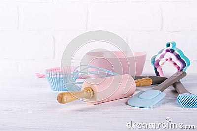 Baking background with kitchen tools: rolling pin, wooden spoons, whisk, sieve, bakeware and shape cookie cutter on white Stock Photo