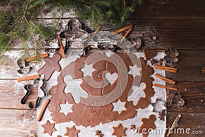 Baking Christmas cookies. Roll out the dough to cut out stars and gingerbreadman on a wooden background Stock Photo