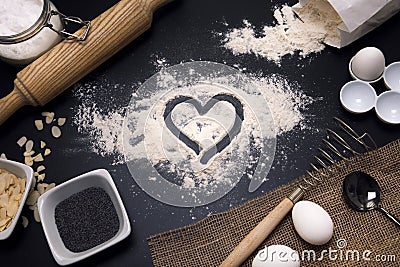 Baking love. Bakery background. Baking ingredients and kitchen utensils on the black background. Flour, almond nuts, eggs. Top Stock Photo