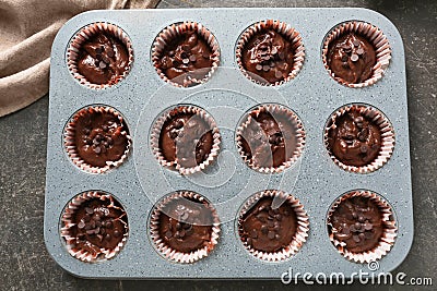 Baking tin with tasty chocolate muffins on table Stock Photo