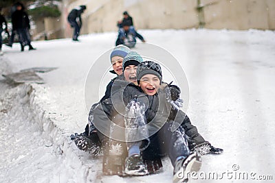 Boys sledding in a snowy . Children ski in the snow . The children were very happy and laughing . Two very happy caucasian kids Editorial Stock Photo