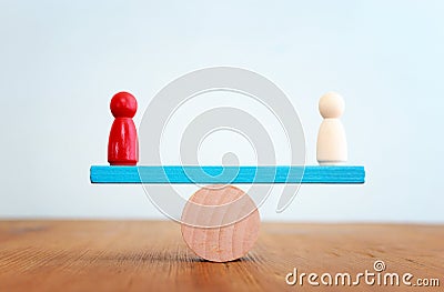 Balance concept. Red person figure on seesaw Stock Photo