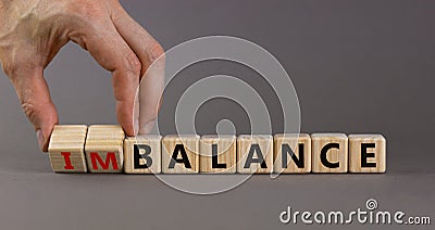 Balance or imbalance symbol. Businessman turns cubes and changes the word imbalance to balance. Beautiful grey background, copy Stock Photo