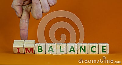 Balance or imbalance symbol. Businessman turns cubes and changes the word imbalance to balance. Beautiful orange background, copy Stock Photo