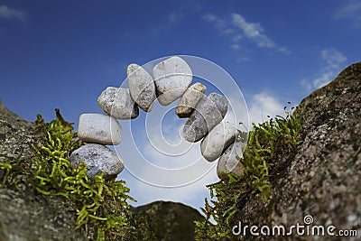 Balanced stone arch of pebbles as zen symbol for a bridge or a g Stock Photo